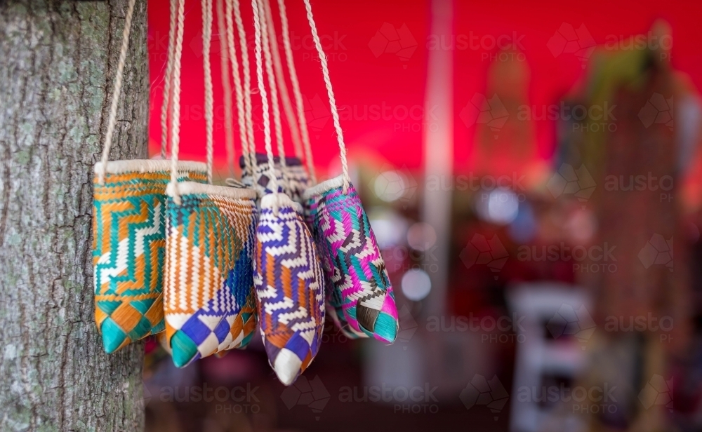 Woven straw bags hanging in tree - Australian Stock Image