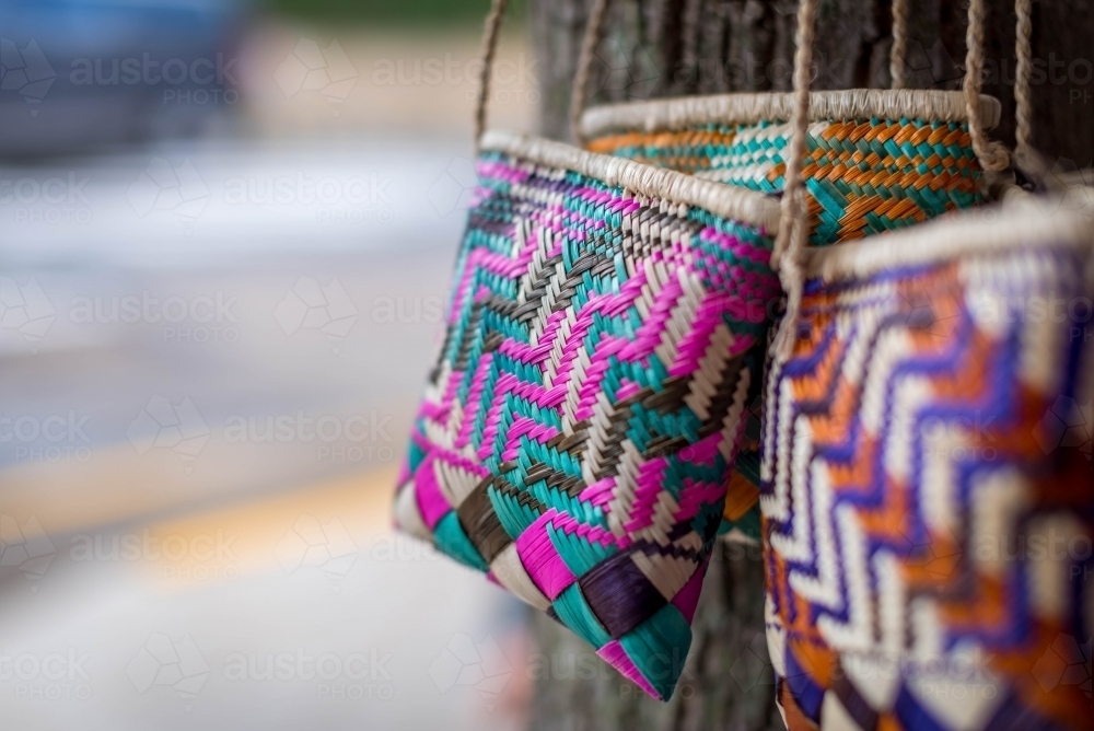 Woven straw bags on tree - Australian Stock Image