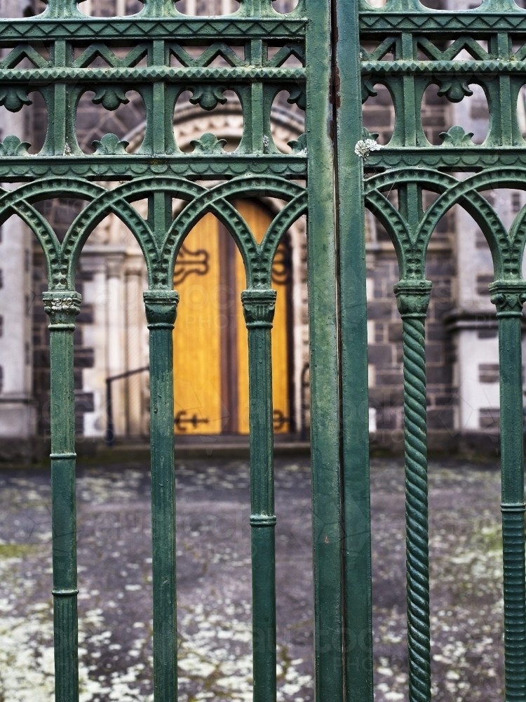 Wrought iron gates with church door in background - Australian Stock Image