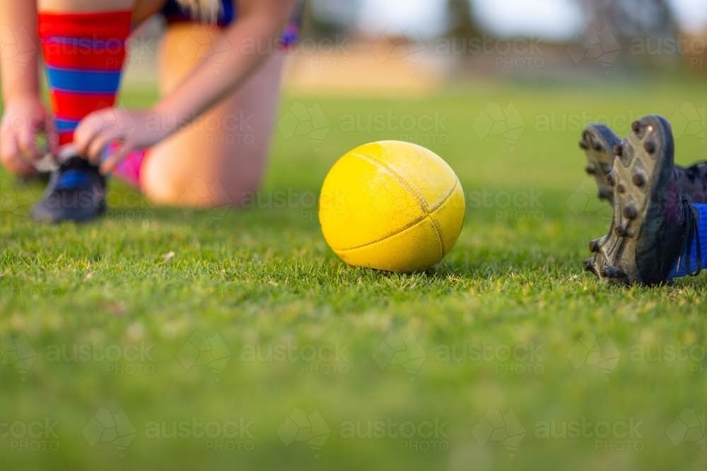 yellow afl football on green grass with detail of players boots : Austockphoto yellow afl football on green grass with detail of players boots - Australian Stock Image