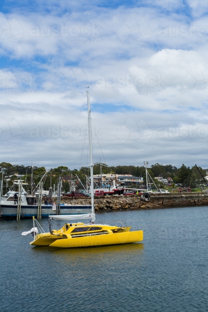 yellow boat (catamaran) in Ulladulla harbour - Australian Stock Image