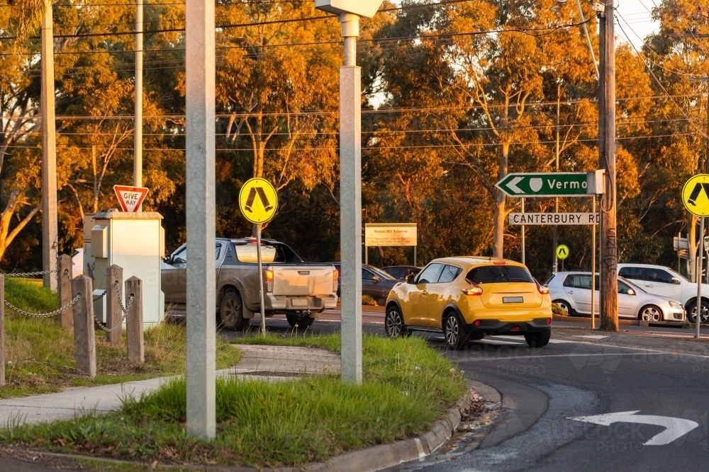 Yellow car in turning lane at traffic intersection in Melbourne with sign directions to Vermont - Australian Stock Image