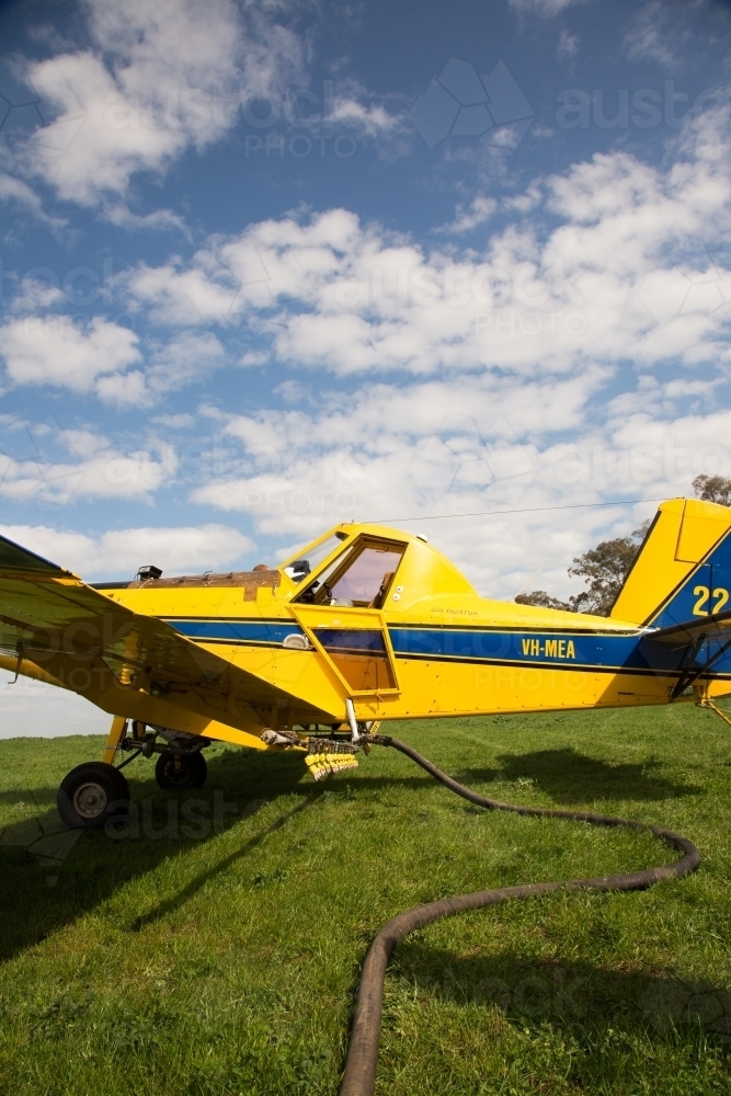 Image of Yellow plane refuelling and reloading - Austockphoto