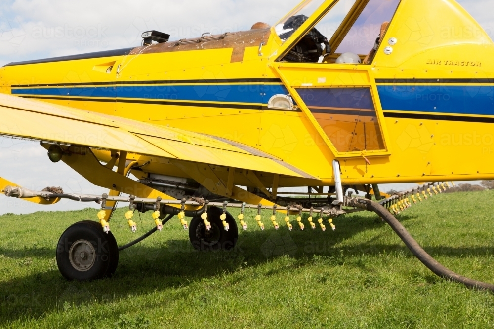 Yellow plane refuelling and reloading - Australian Stock Image