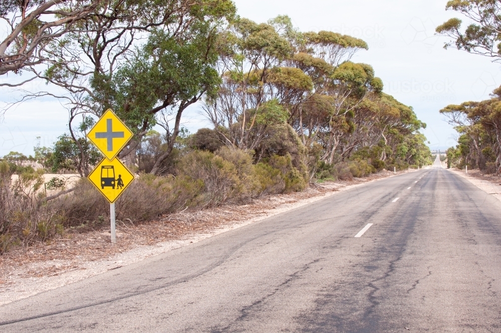 Yellow school bus sign on long rural road - Australian Stock Image