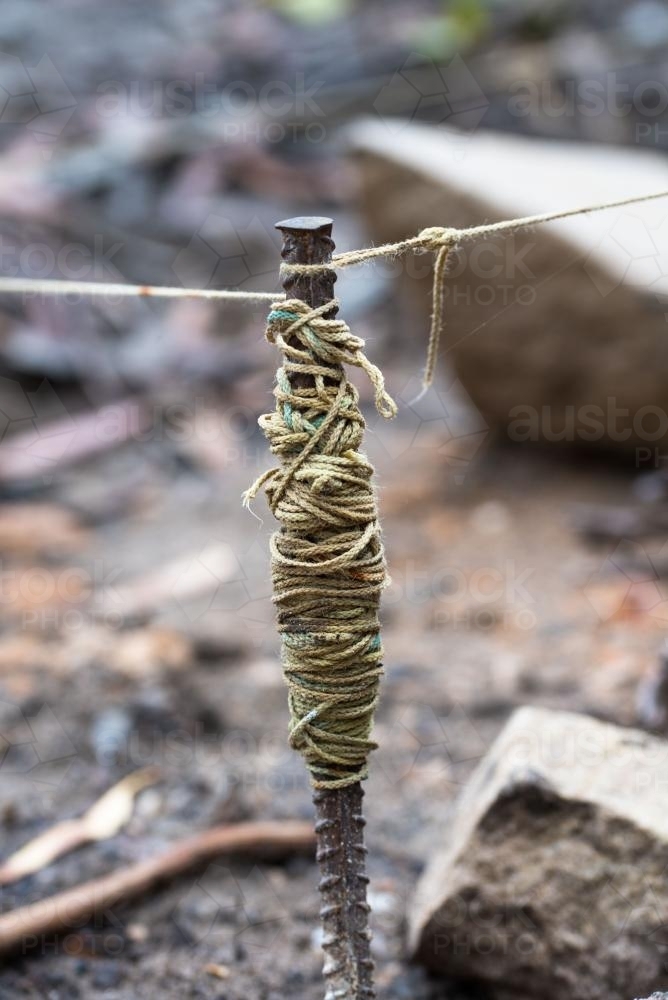 Image of Yellow string line wrapped around steel stake - Austockphoto