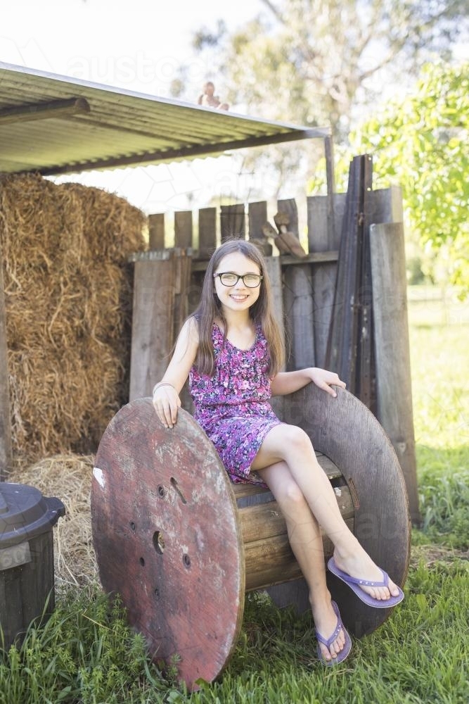 You girl sitting outside on an old reel - Australian Stock Image