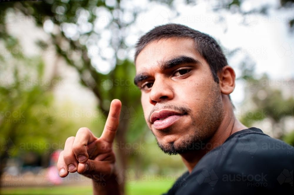 Young Aboriginal Adult Outdoors Pointing Finger - Australian Stock Image