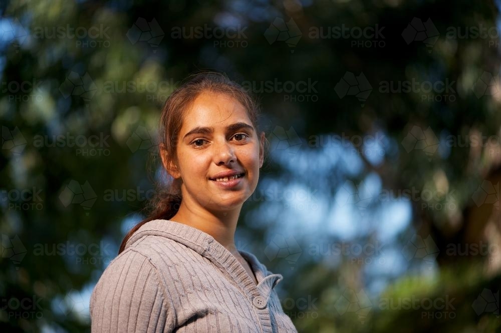Young Aboriginal Australian Woman Photographed Against Trees - Australian Stock Image