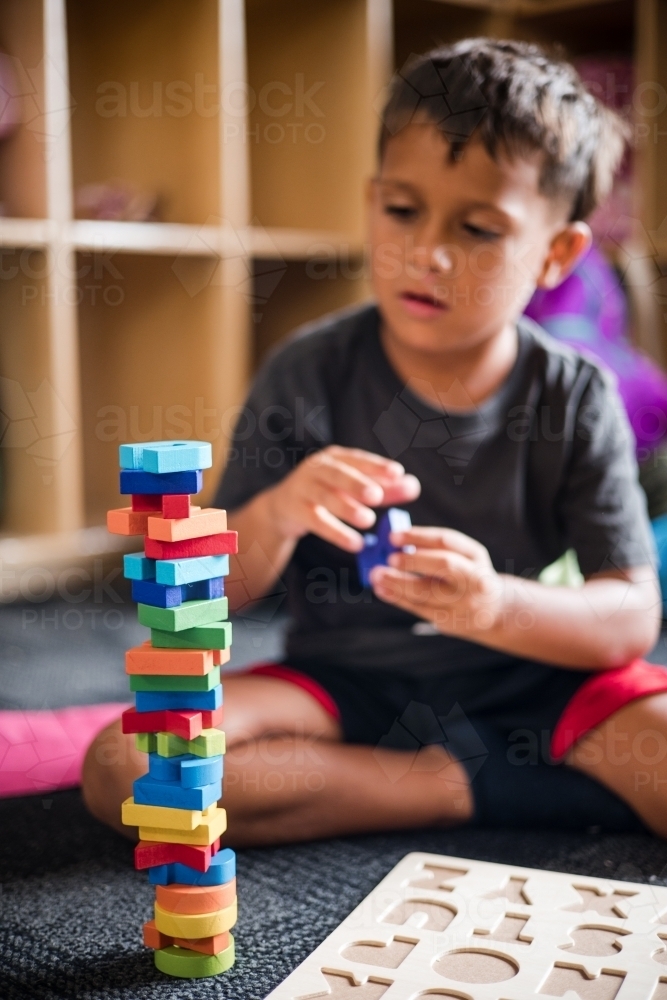 Young Aboriginal boy doing a letter puzzle - Australian Stock Image