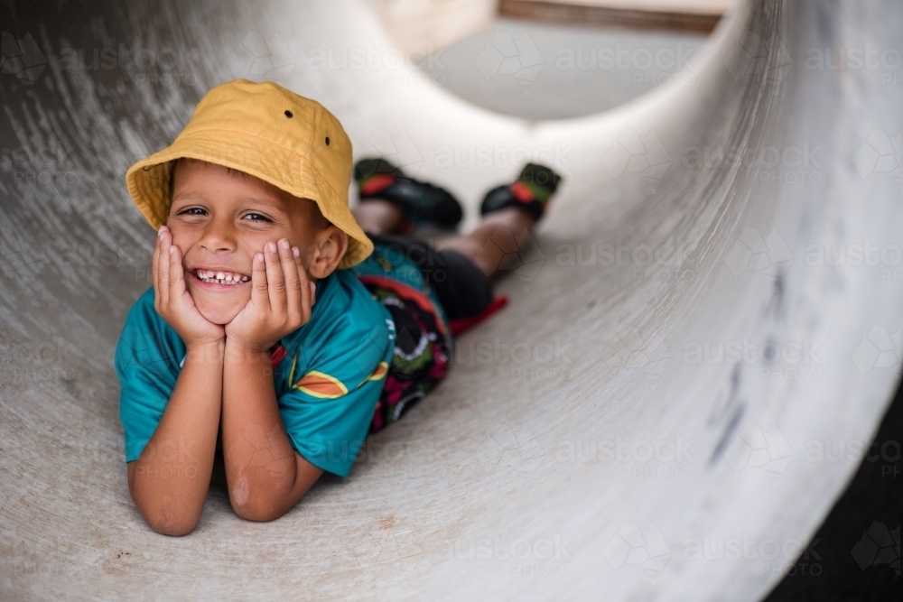 Young Aboriginal boy lying in a tunnel - Australian Stock Image