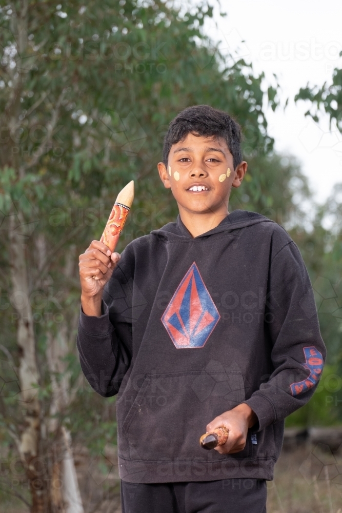 Young Aboriginal Boy with clapstick instrument - Australian Stock Image
