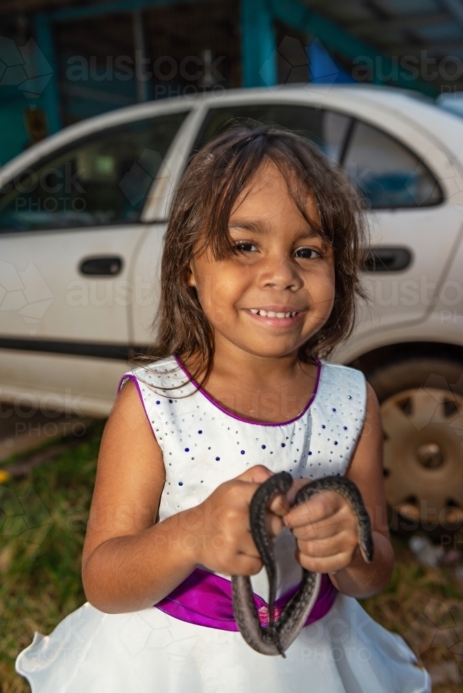 Young aboriginal girl holding pet snake - Australian Stock Image