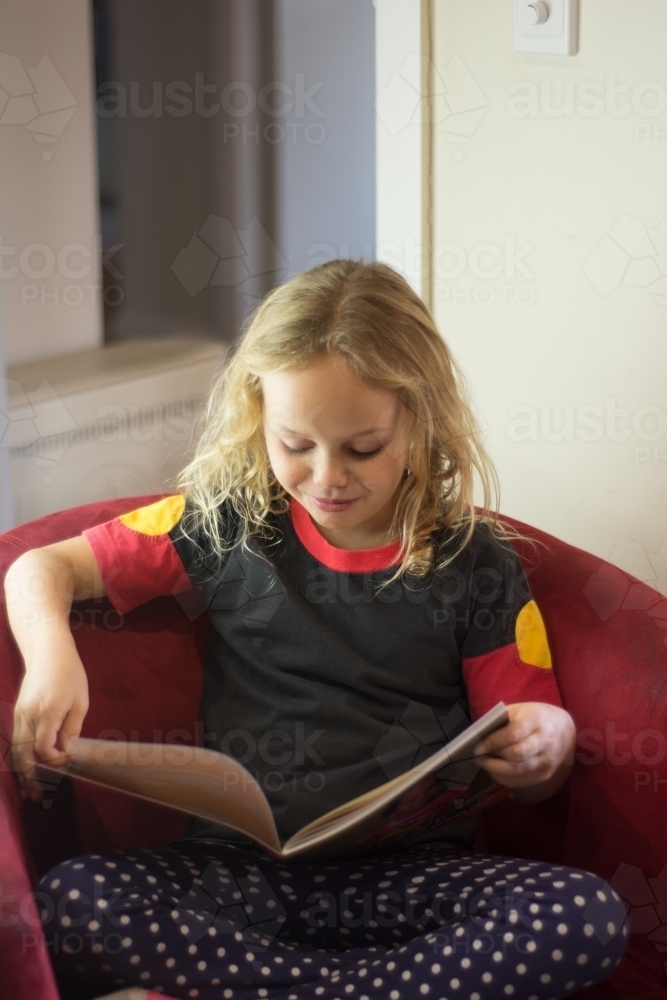 Young Aboriginal girl reading - Australian Stock Image