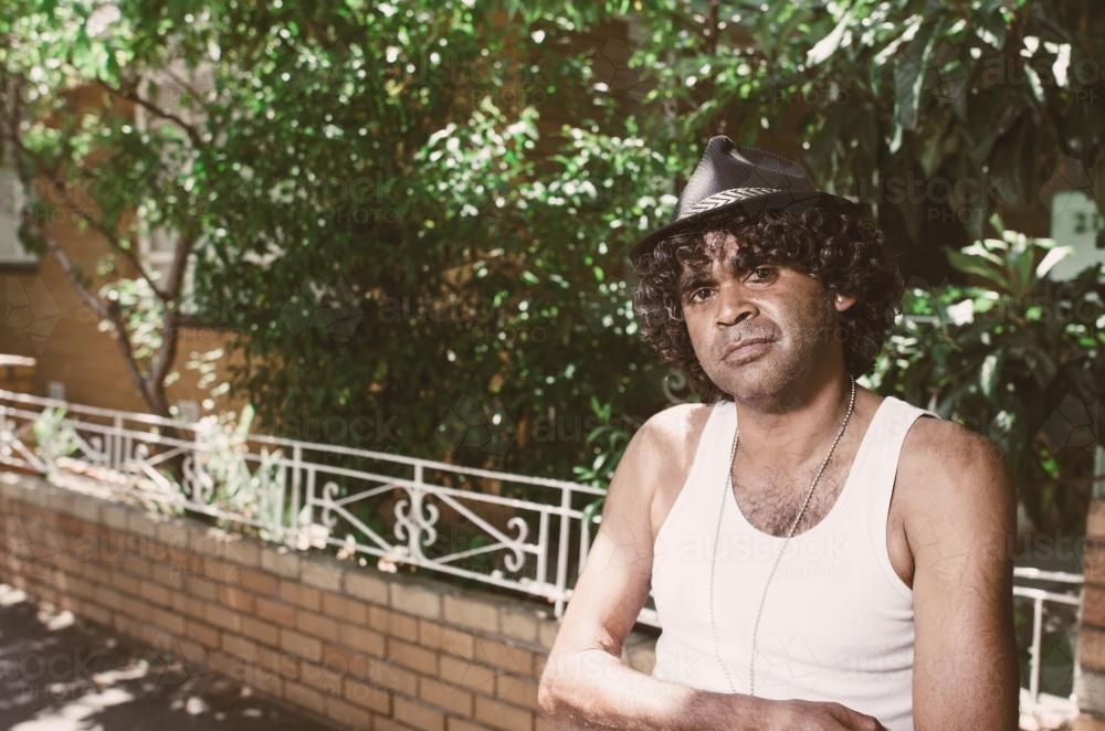 Young Aboriginal Man with Folded Arms in a Suburban Street - Australian Stock Image