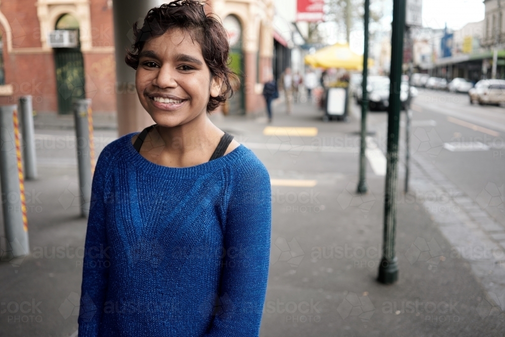 Young Aboriginal Woman in town street - Australian Stock Image