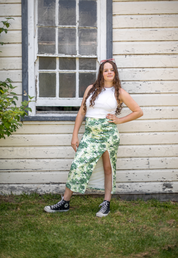Young adult female posing in front of old window of a country shed - Australian Stock Image