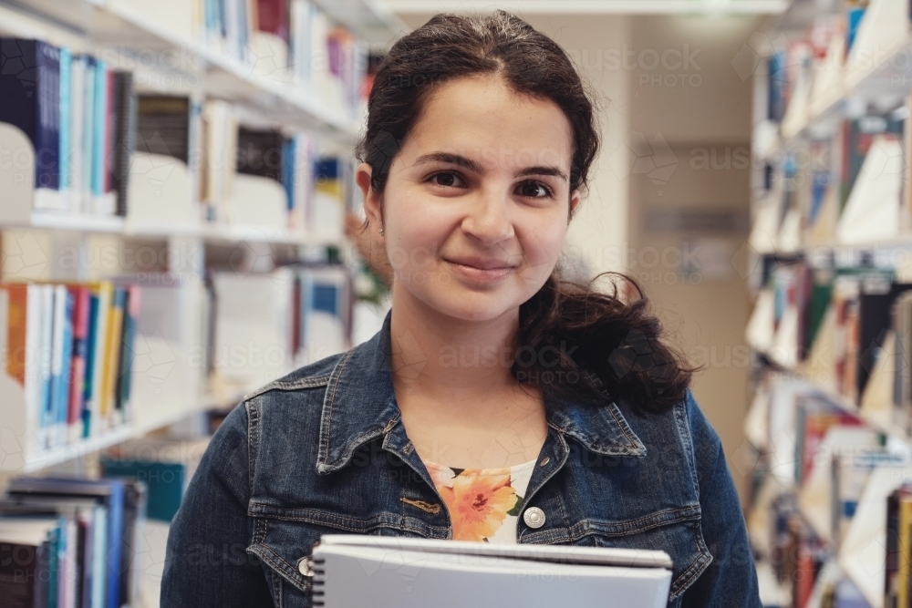 Young adult student in university library - Australian Stock Image