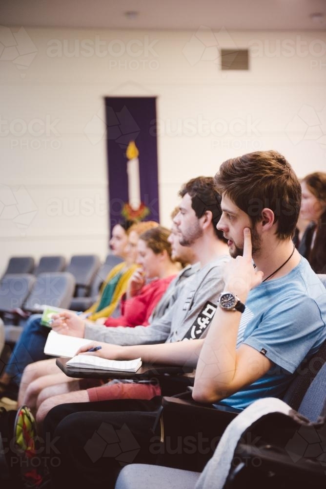 Young adult students looking bored in a university lecture hall - Australian Stock Image
