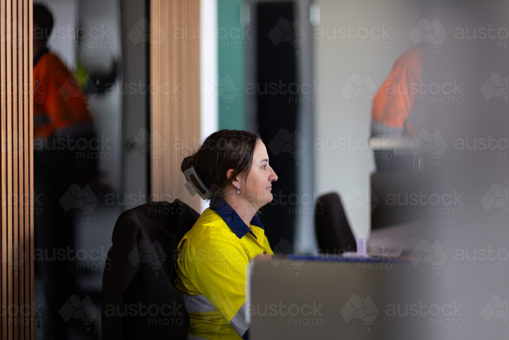 Young adult woman working in front of the computer in the office. - Australian Stock Image