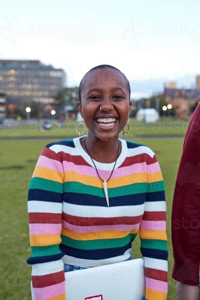 Young African girl at university campus laughing whilst looking at camera - Australian Stock Image