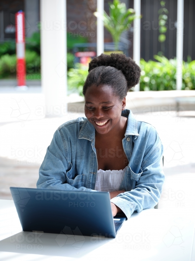 Image of Young African woman using a computer on university campus ...