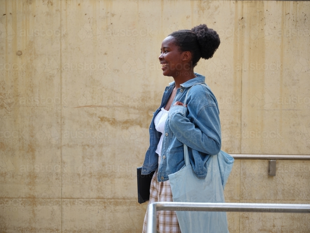 Young African woman with a tote bag on university campus - Australian Stock Image