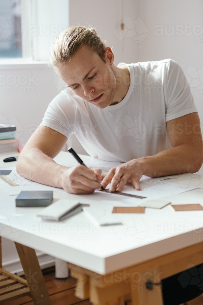 Young architect working on a house design vertical - Australian Stock Image