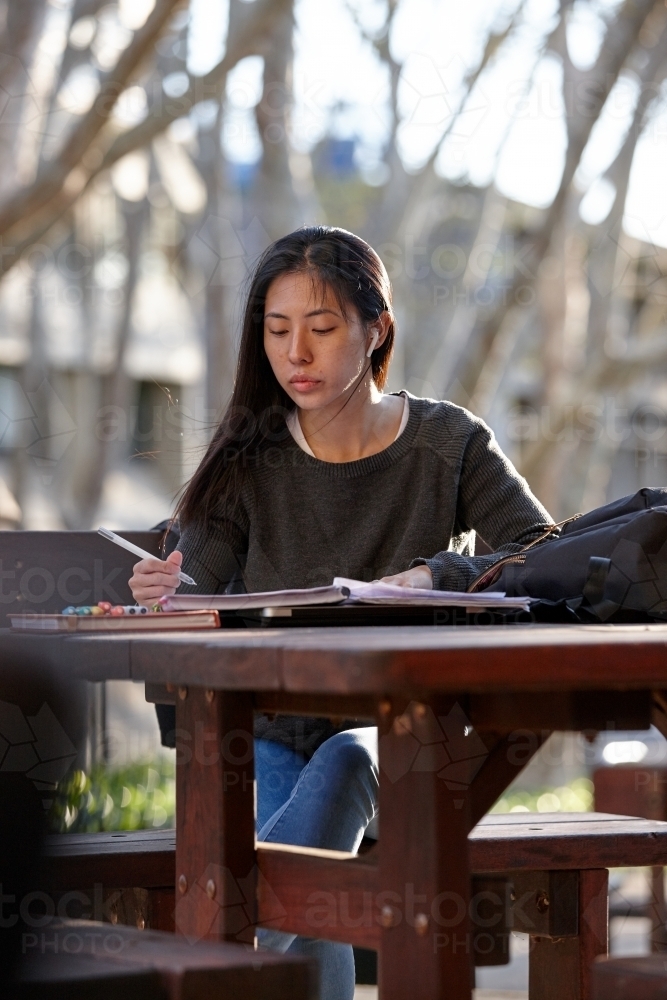 Image of Young Asian female university student studying outdoors ...