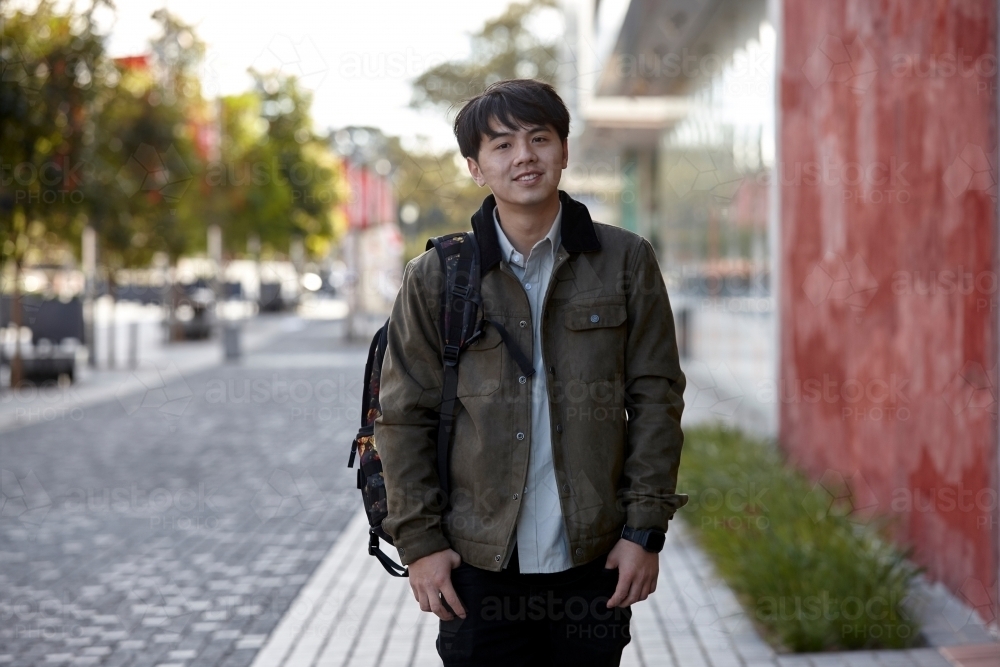 Young Asian student looking at camera on-campus at university - Australian Stock Image