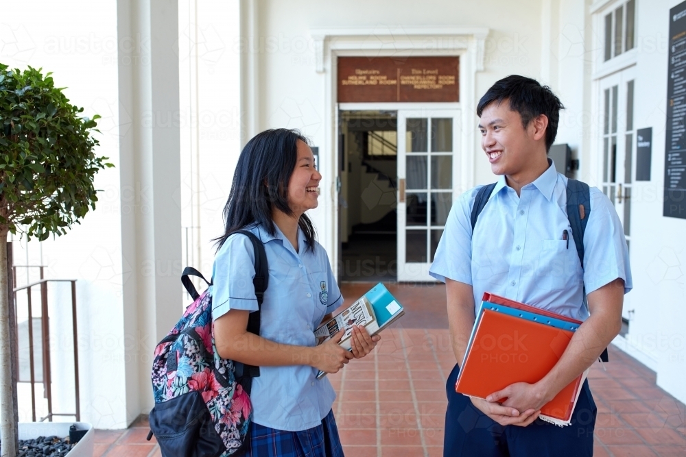 Young Asian teenager friends talking at high school campus - Australian Stock Image
