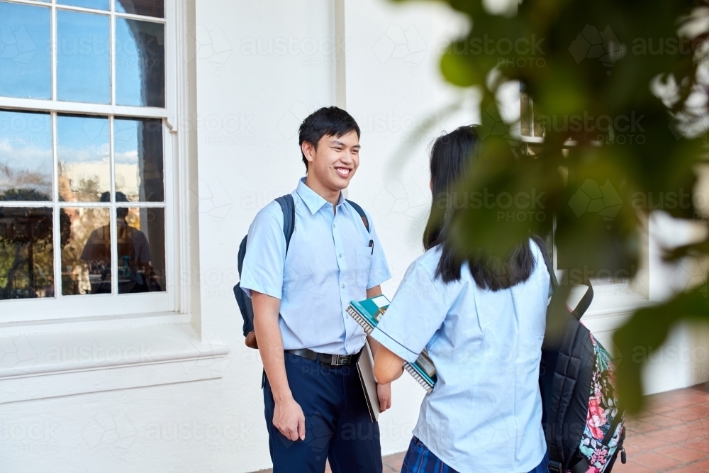 Young Asian teenager friends talking at high school campus - Australian Stock Image
