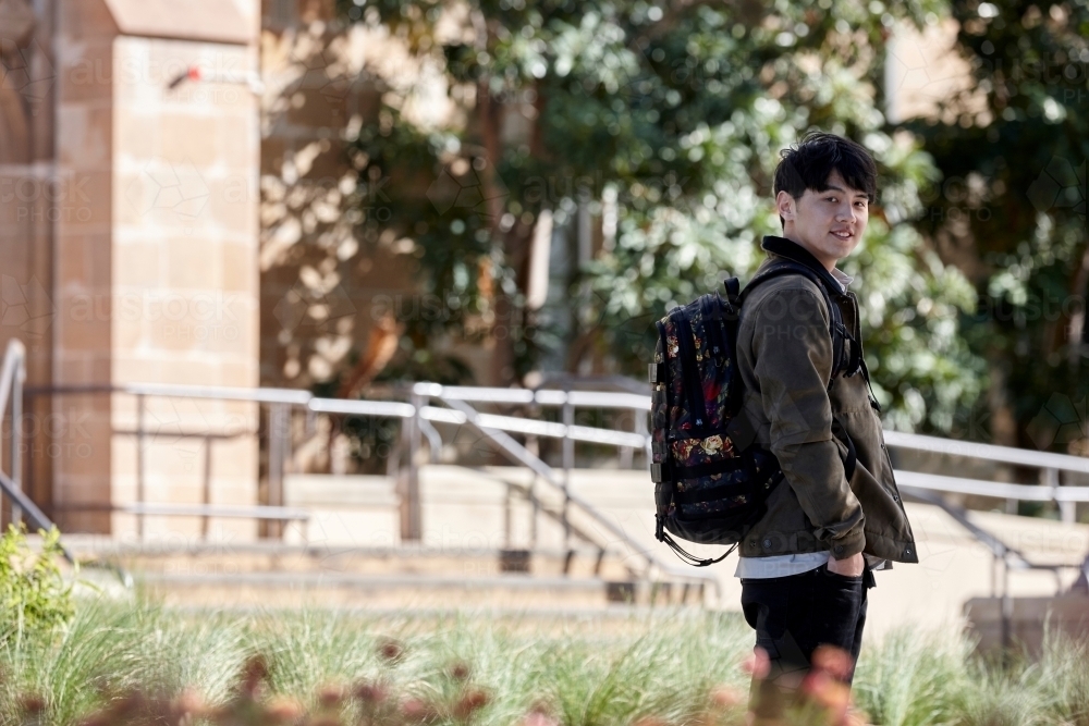 Young Asian university student walking on-campus - Australian Stock Image
