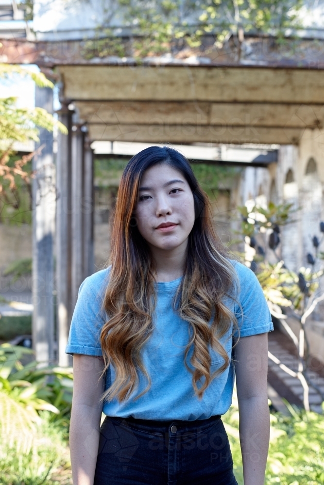 Young Asian woman enjoying time outdoors at enclave - Australian Stock Image