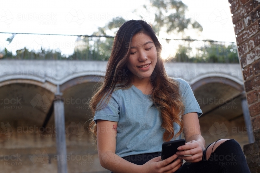 Young Asian woman enjoying time outdoors at enclave - Australian Stock Image