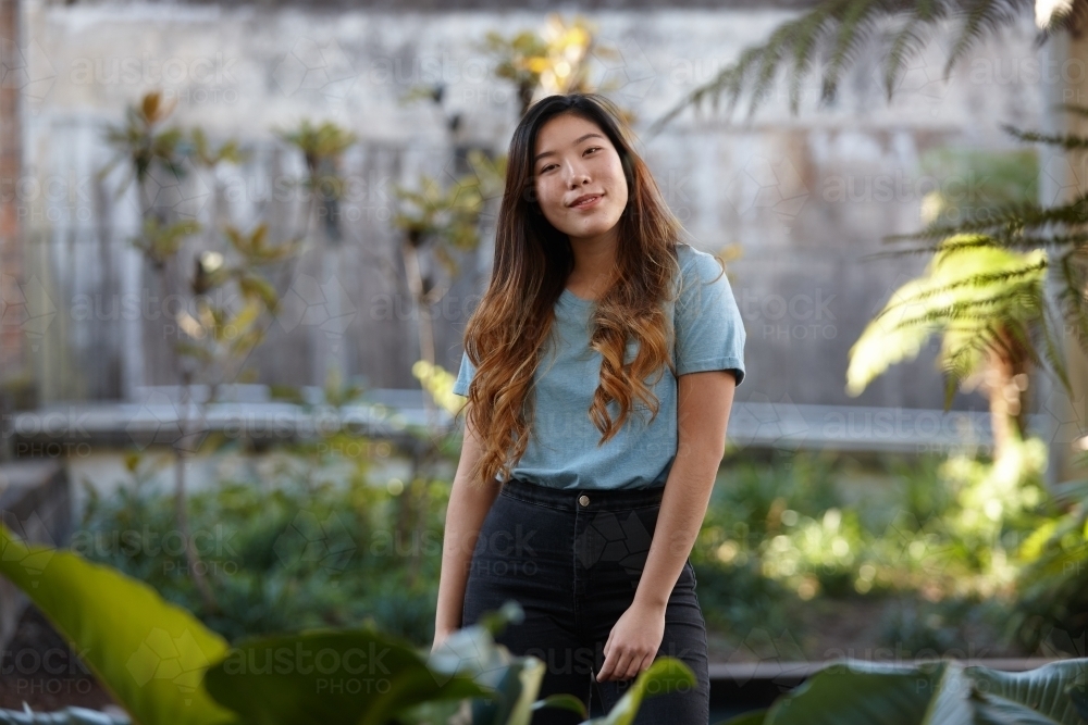 Young Asian woman enjoying time outdoors at enclave - Australian Stock Image