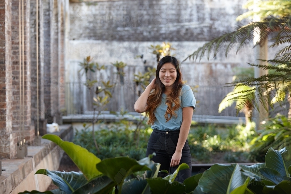 Young Asian woman enjoying time outdoors at enclave - Australian Stock Image