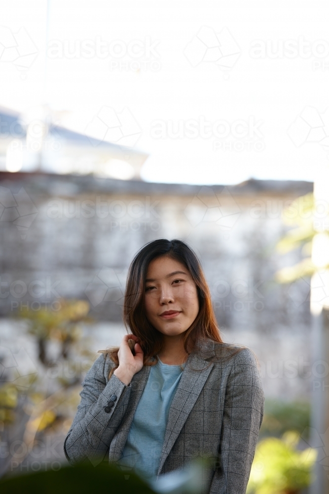 Young Asian woman enjoying time outdoors at enclave - Australian Stock Image
