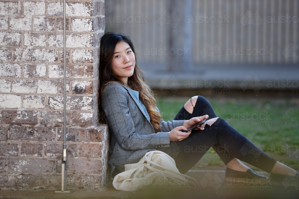 Young Asian woman enjoying time outdoors at enclave - Australian Stock Image