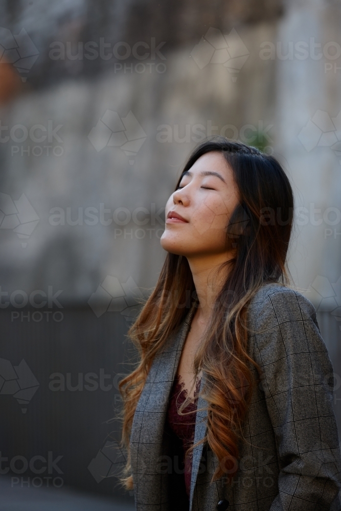 Young Asian woman enjoying time outdoors at enclave - Australian Stock Image