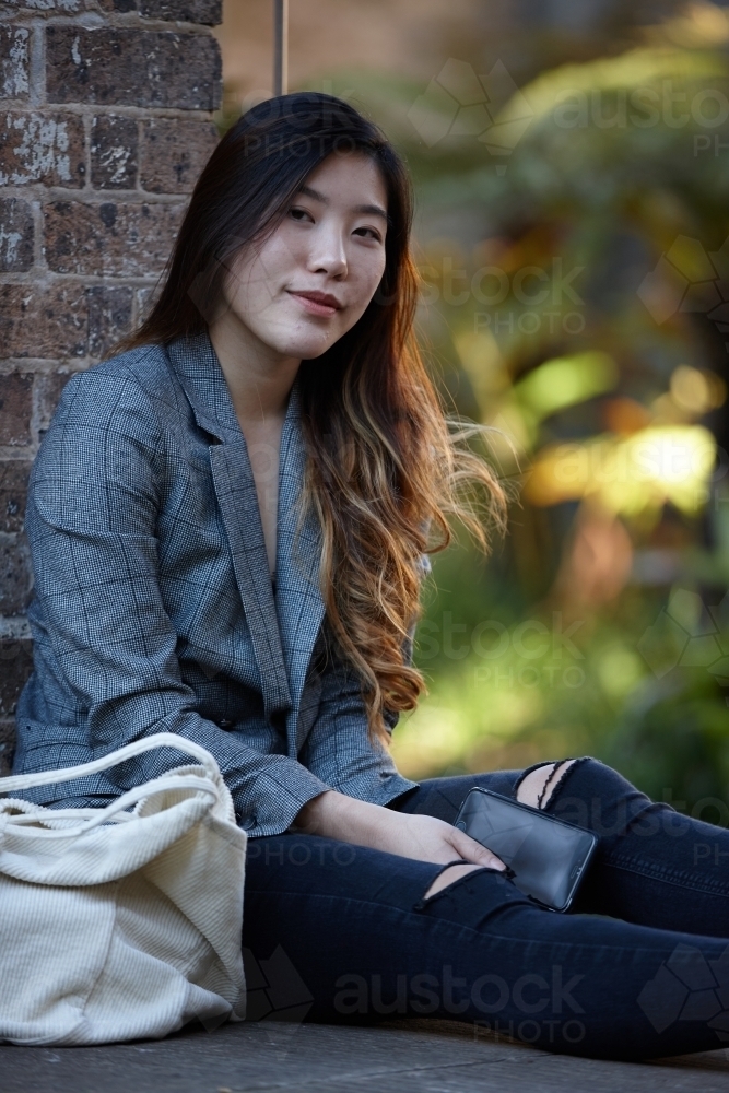 Young Asian woman enjoying time outdoors at enclave - Australian Stock Image