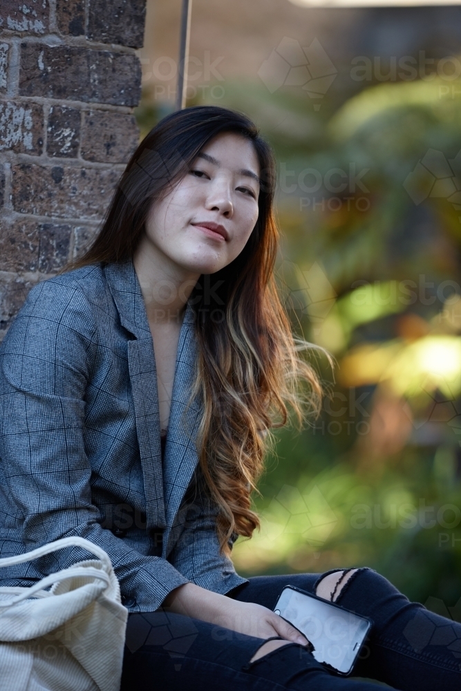 Young Asian woman enjoying time outdoors at enclave - Australian Stock Image
