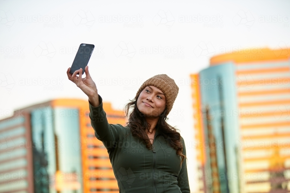 Young Asian woman having fun with mobile phone in city - Australian Stock Image