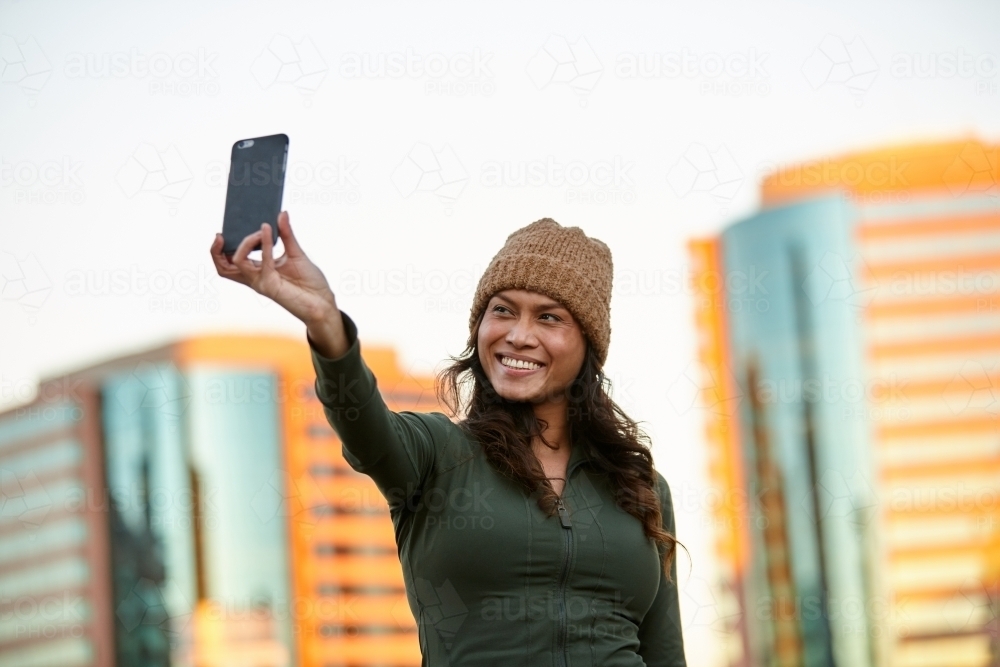 Young Asian woman having fun with mobile phone in city - Australian Stock Image