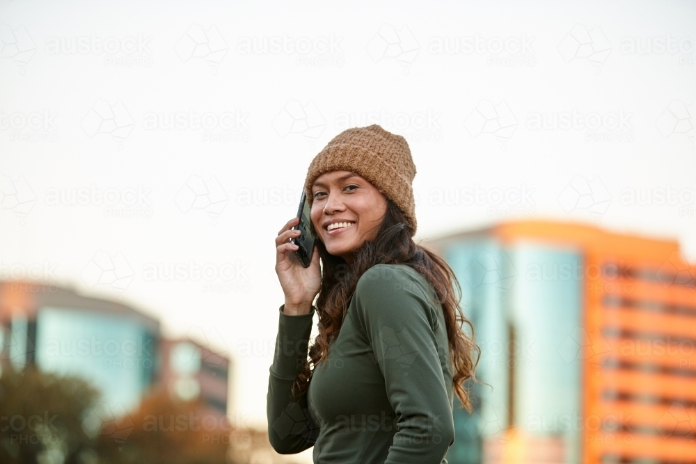 Young Asian woman having fun with mobile phone in city - Australian Stock Image