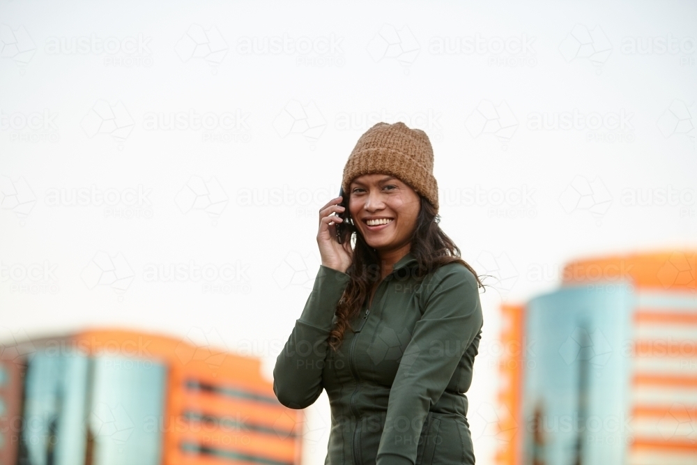 Young Asian woman having fun with mobile phone in city - Australian Stock Image