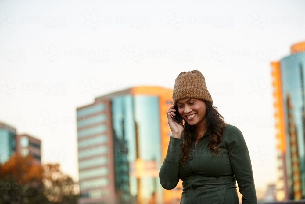 Young Asian woman talking on mobile phone in city - Australian Stock Image