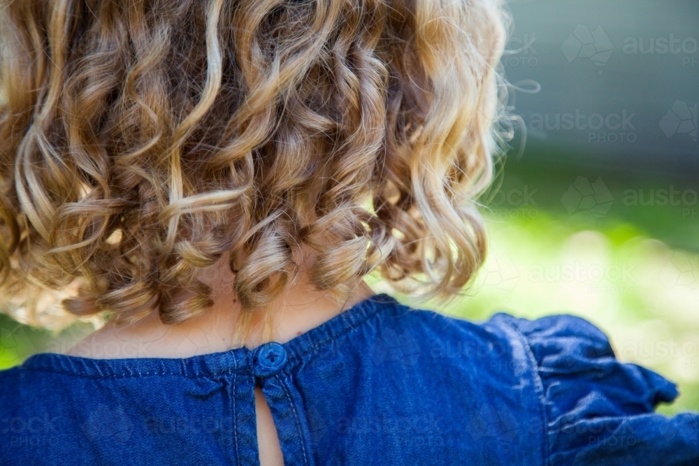 Young blonde child with beautiful natural curls in her hair - Australian Stock Image