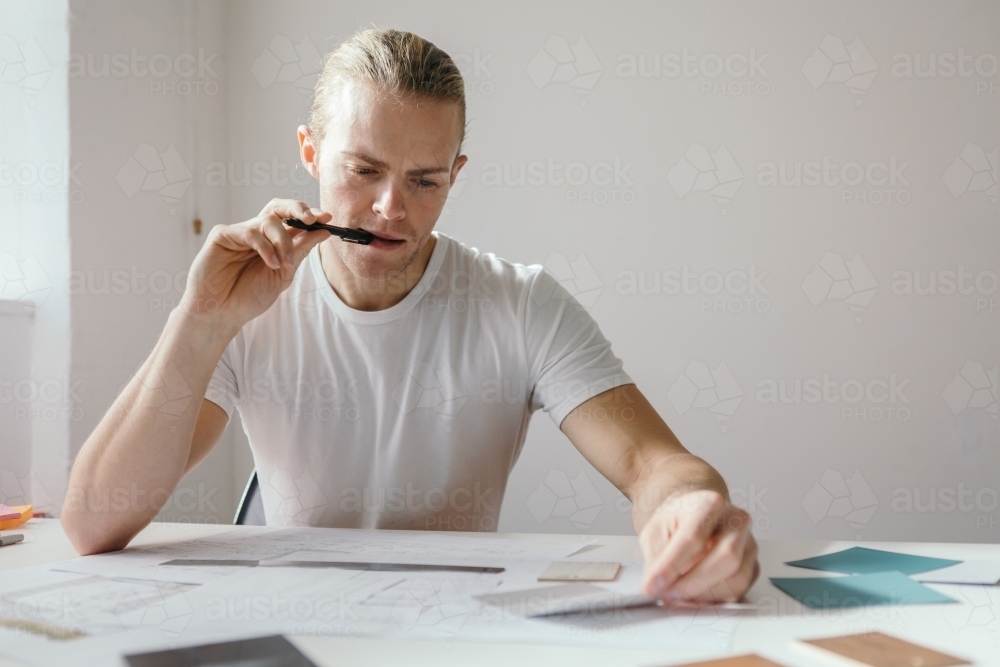 Young blonde male at work deep in thought with clear space - Australian Stock Image