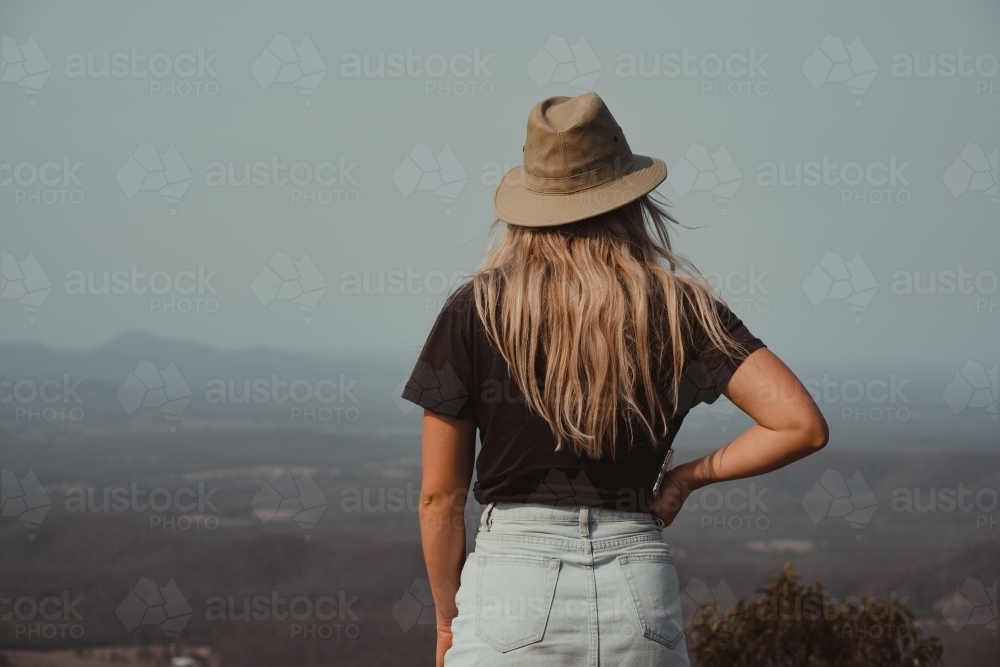 Young blonde woman enjoying the view at the top of a mountain - Australian Stock Image